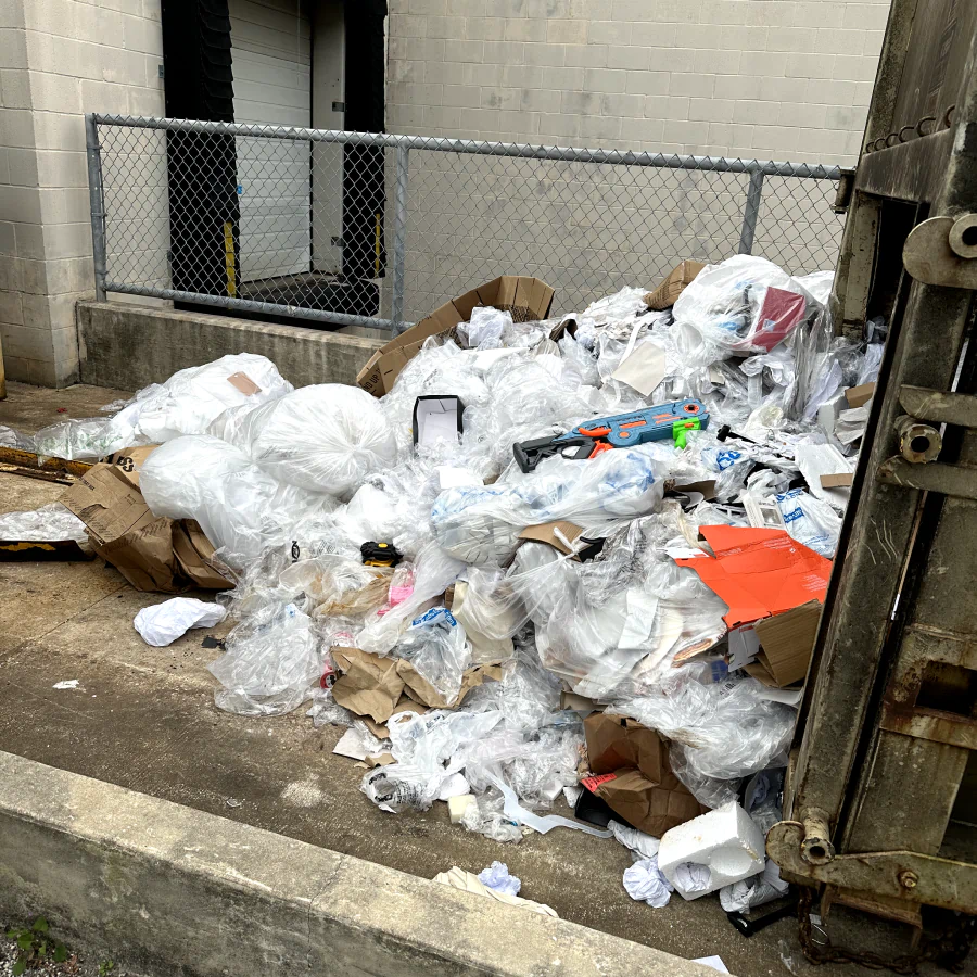 junk outside of a building with cardboard pieces